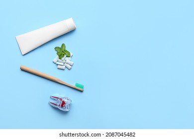 Chewing gums, toothbrush and paste on color background