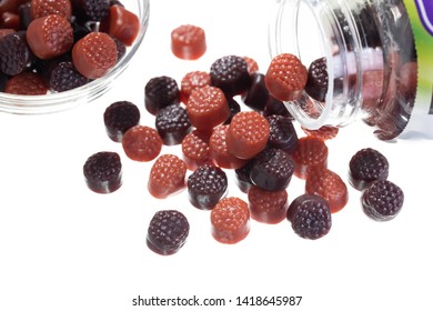 Chewy Gummy Multivitamins In A Bowl And A Spilled Bottle With White Background