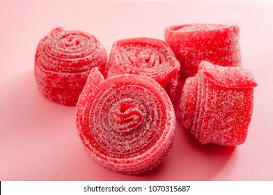 Chewy Sweets And Strawberry And Cherry Flavoured Gummy Candy Concept With Close Up On Sweet And Sour Red Sour Belts Covered In Sugar Isolated On A Pink Background