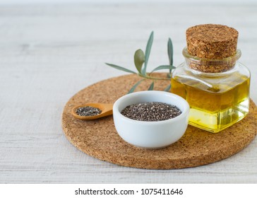 Chia Oil With Seed On White Wooden Table Background.