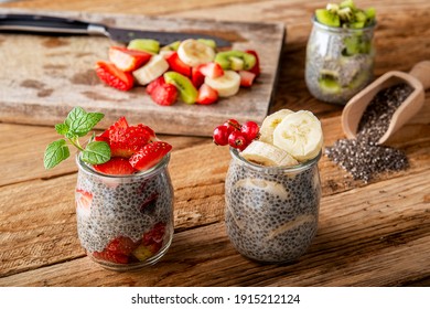 Chia Pudding In Glass Jar Stawberry Banana Kiwi On Wooden Plank