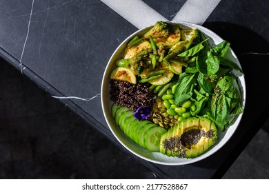 Chia Salad With Tomatoes, Broccoli, Basil, Broccoli, Zucchini, Cucumber, Asparagus Beans, Sesame Seeds, Watermelon Seeds, Avocado, Beans, Violet Flower In A Plate On A Background With A Letter