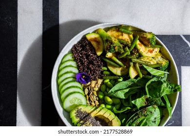 Chia Salad With Tomatoes, Broccoli, Basil, Broccoli, Zucchini, Cucumber, Asparagus Beans, Sesame Seeds, Watermelon Seeds, Avocado, Beans, Violet Flower In A Plate On A Background With A Letter