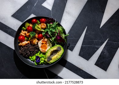 Chia Salad With Tomatoes, Shrimps, Broccoli, Arugula, Sesame Seeds, Endive, Mashed Potatoes, Avocado, Beans, Violet Flower In A Plate On A Background With A Letter