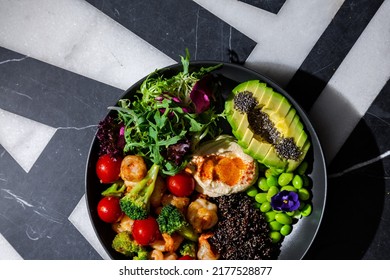 Chia Salad With Tomatoes, Shrimps, Broccoli, Arugula, Sesame Seeds, Endive, Mashed Potatoes, Avocado, Beans, Violet Flower In A Plate On A Background With A Letter