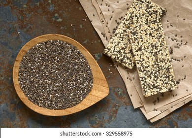 Chia Seeds (lat. Salvia Hispanica) On Small Plate And Chia-sesame-honey Granola Bar, Photographed Overhead With Natural Light. Chia Is Considered A Superfood.