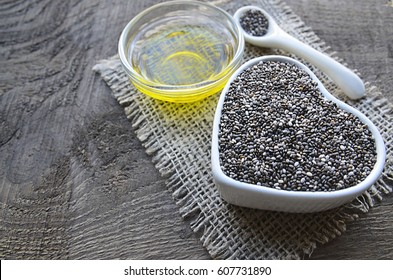 Chia Seeds With Chia Oil On Old Wooden Background.Organic Chia Seed Oil.Healthy Food,superfood Or Bodycare Concept