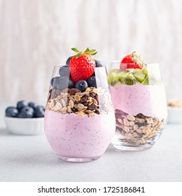 Chia seeds pudding with granola, blueberry and strawberry in glasses. Yogurt with chia seeds, berries, kiwi and muesli for healthy breakfast, copy space - Powered by Shutterstock