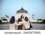 Chiang Kai-shek Memorial Hall, known in Taipei as the middle of the arch, can be seen through the eyes of three Asian women tourists holding bubble tea glasses. Liberty Square, Taipei, Taiwan