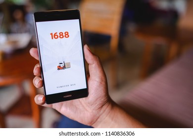 CHIANG MAI, THAILAND - April 17,2018: Man hands holding HUAWEI with 1688 apps on the screen.1688.com also called Alibaba.cn is the popular Chinese versions of Alibaba.com.