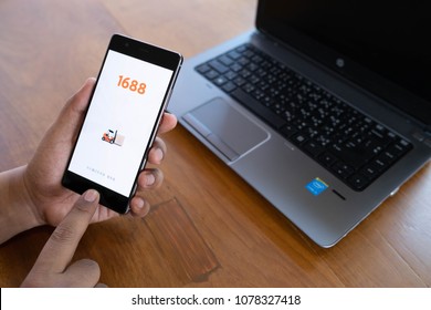 CHIANG MAI, THAILAND - April 21,2018: Man hands holding HUAWEI with 1688 apps on the screen.1688.com also called Alibaba.cn is the popular Chinese versions of Alibaba.com.