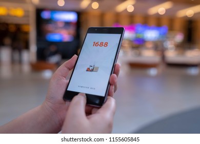 CHIANG MAI, THAILAND - August 03,2018: Woman hands holding HUAWEI with 1688 apps on the screen.1688.com also called Alibaba.cn is the popular Chinese versions of Alibaba.com.