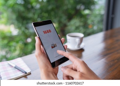 CHIANG MAI, THAILAND - August 18,2018: Woman hands holding HUAWEI with 1688 apps on the screen.1688.com also called Alibaba.cn is the popular Chinese versions of Alibaba.com.