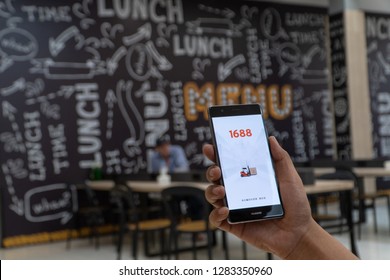 CHIANG MAI, THAILAND - JAN. 06,2019: Man holding HUAWEI with 1688 apps on the screen.1688.com also called Alibaba.cn is the popular Chinese versions of Alibaba.com.