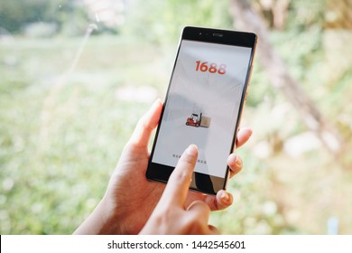 CHIANG MAI, THAILAND - JAN. 19,2019: Women holding HUAWEI with 1688 apps on the screen.1688.com also called Alibaba.cn is the popular Chinese versions of Alibaba.com.