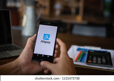 CHIANG MAI, THAILAND - JULY 09, 2018 : A man holding Phone with Alipay logo, Alipay is application from china.