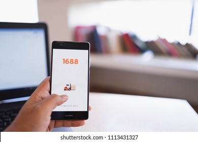 CHIANG MAI, THAILAND - June 03,2018: Man hands holding HUAWEI with 1688 apps on the screen.1688.com also called Alibaba.cn is the popular Chinese versions of Alibaba.com.