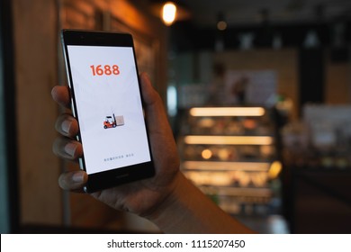 CHIANG MAI, THAILAND - June 09,2018: Man hands holding HUAWEI with 1688 apps on the screen.1688.com also called Alibaba.cn is the popular Chinese versions of Alibaba.com.