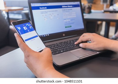 CHIANG MAI, THAILAND - Mar 18,2018: Man hands holding HUAWEI with facebook app on the screen. Facebook is a popular free social  media are used for information sharing and networking.