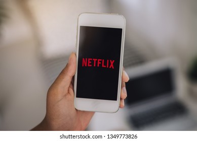 Chiang Mai, Thailand - March 16, 2019 : women use Netflix app on smart phone screen. Netflix is an international leading subscription service for watching TV episodes and movies.