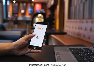 CHIANG MAI, THAILAND - May 05,2018: Man hands holding HUAWEI with 1688 apps on the screen.1688.com also called Alibaba.cn is the popular Chinese versions of Alibaba.com.