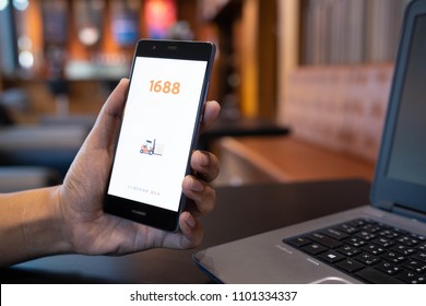 CHIANG MAI, THAILAND - May 05,2018: Man hands holding HUAWEI with 1688 apps on the screen.1688.com also called Alibaba.cn is the popular Chinese versions of Alibaba.com.