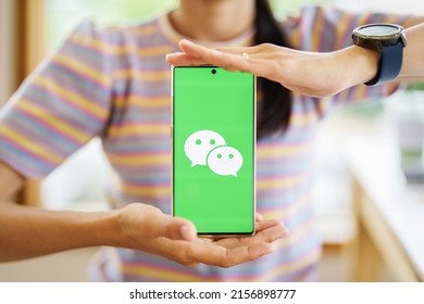 CHIANG MAI, THAILAND - May 13, 2022 : Women holds smartphone mobile with WeChat app on the screen.WeChat is a Chinese multi-purpose messaging, social media and mobile payment app