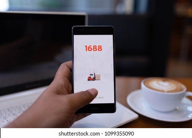 CHIANG MAI, THAILAND - May 19,2018: Man hands holding HUAWEI with 1688 apps on the screen.1688.com also called Alibaba.cn is the popular Chinese versions of Alibaba.com.