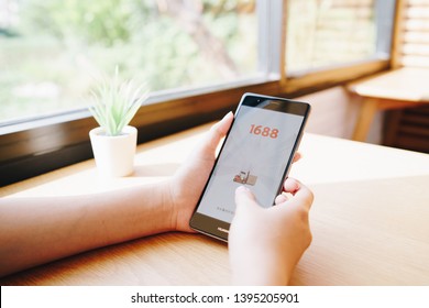 CHIANG MAI, THAILAND - May.01,2019: Women holding HUAWEI with 1688 apps on the screen.1688.com also called Alibaba.cn is the popular Chinese versions of Alibaba.com.