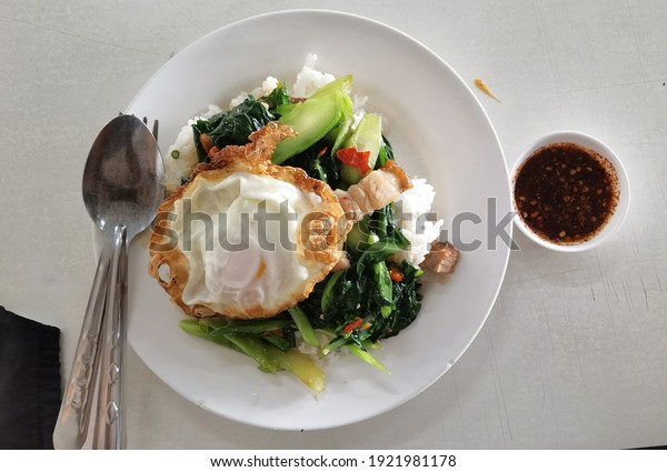 Chiang Mai, THAILAND - NOVEMBER 19,2019:This\
food is called Stir Fried Kale with Crispy Pork It is Thai food\
with a spicy car. And inexpensive, you can easily find it in Chiang\
Mai, Thailand.