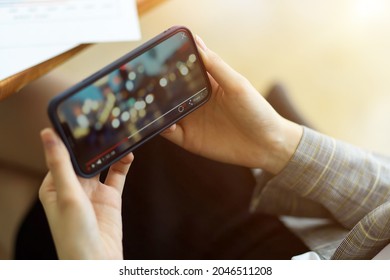 Chiang Mai, Thailand-SEP24 2021: Female Is Watching A Video On Her Smart Phone While Holding It Horizontally. Bokeh Video, Enjoyment, Relaxation