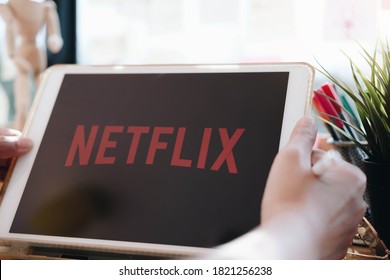 CHIANG MAI,THAILAND - APR 06, 2020 : Woman using iPad pro open Netflix application at home. Netflix is a global provider of streaming movies and TV series.