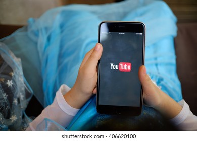 CHIANG MAI,THAILAND - APR 17, 2016 : Brand new Apple iPhone 6 plus with YouTube app on the screen lying on old wood desk with headphones. YouTube is the popular online video sharing website
