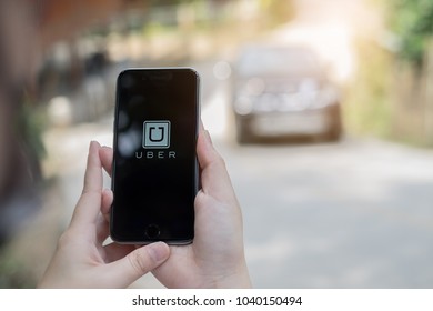 CHIANG MAI,THAILAND - MARCH 01, 2018 : A Uber Driver Hand Holding Uber App Showing On IPhone 6s On Road And Black Car, Uber Is Smartphone App-based Transportation Network.