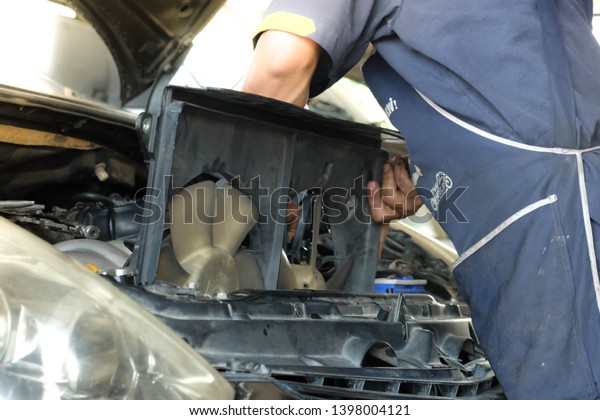 Chiang rai, Thailand - April 30,2019: Car Radiator\
fan,The car  technicians is changing the new radiator fan in the\
car.
