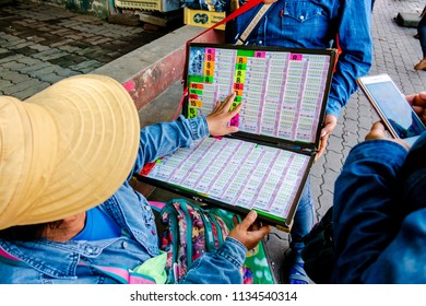 Chiang Rai, Thailand - July 9th 2018 : Thai Government Lottery Ticket Sellers In The Street Market And Customer Choose Lottery Tickets To Buy For Wish To Reward Of Gamble.