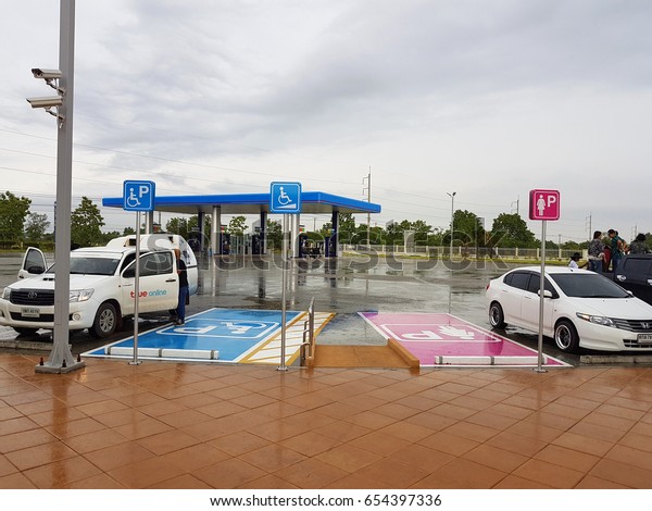 CHIANG RAI, THAILAND - MAY 8 : Lady\
parking sign and disabled sign with two white cars after raining in\
gas station on May 8, 2017 in Chiang rai,\
Thailand.