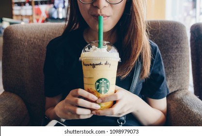 Chiang Rai, Thailand : May-23-2018 : Asian Girl Drinking Starbucks Mango Fruit Jelly Yogurt Frappuccino In Starbucks Coffee Shop. (This Menu Is Limited Only In Southeast Asia)