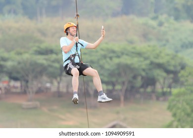 Chiang Rai, Thailand. November 24, 2017. Man Tourist Wearing Casual Clothing Is Playing Zip Line And Selfie At Singha Park Chiang Rai. Thailand