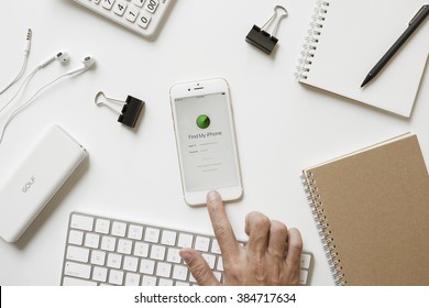 CHIANGMAI, THAILAND - FEBRUARY 16, 2016: Man Hand Touching On Apple IPhone 6s Button And Open Find My IPhone IOS App On Office Desk.