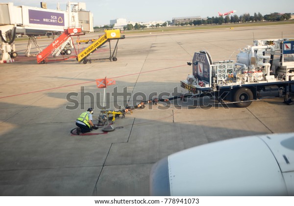 Chiangmai-Thailand. December,16,2017. Technician\
fill the petroleum oil in DD8316 NOKAIR on airfield at Don Mueang\
International Airport in Bangkok,\
Thailand