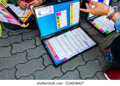 ChiangRai, Thailand - July 9th 2018 : Thai Government Lottery Ticket Sellers In The Street Market And Customer Choose Lottery Tickets To Buy For Wish To Reward Of Gamble.