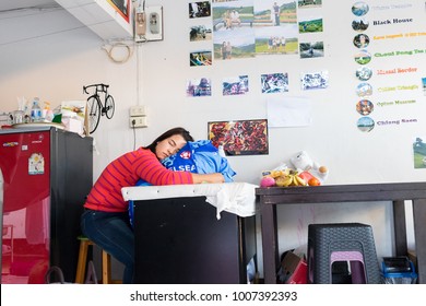 ChiangRai THAILAND-1:21:2018:The female employee in a laundromat is sleeping. in ChiangRai Thailand. - Shutterstock ID 1007392393