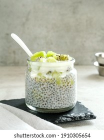 Chiaseed served in a glass jar topped with yogurt and kiwi fruit. Very fresh and healthy. Perfect for breakfast. Blurred background and selective focus image. 
