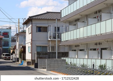 CHIBA, JAPAN - April 24, 2020: A Typical Suburban Japanese Street With A Mixture Of Old And New Housing And Overhead Cables. It Doesn't Have A Sidewalk. It Is In Ichikawa City In Chiba Prefecture.