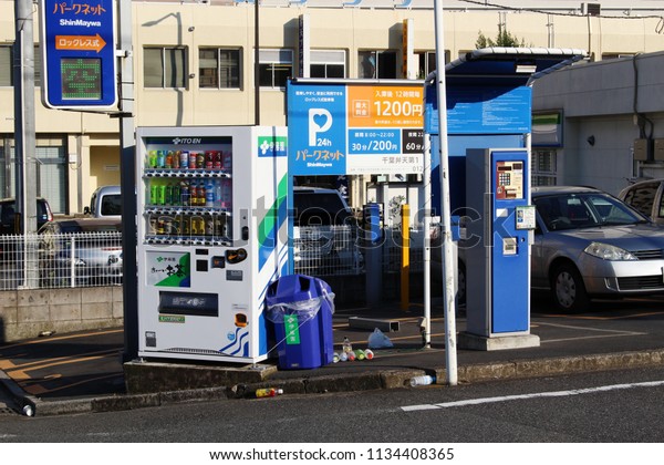 CHIBA, JAPAN - July 15, 2018: A drinks vending\
machine on the edge of a car park next to a ticket payment\
machine\
 in Chiba City.