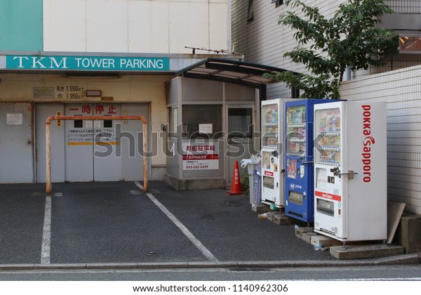CHIBA, JAPAN - July 17, 2018: The forecourt of a\
tower parking facility with a row of three drinks vending machine\
in Chiba City.