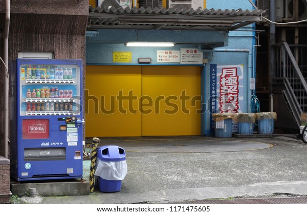 CHIBA, JAPAN - May 8, 2018: An automated\
parking tower\'s entrance and turntable with a drinks vending\
machine in front of it in central Chiba\
City.