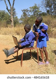 Chibero,Zimbabwe, October 7 2015.Two  primary  schoolkids  using a laptop outside  their  home .More African  children  now  have  access to  computers.                              