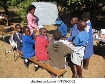 Chibero,Zimbabwe,24May 2015. A  Class  Of  3rd  Graders And Teacher  Conducting  Lessons  Under A  Tree  Because Of Classroom  Shortage At The  School.